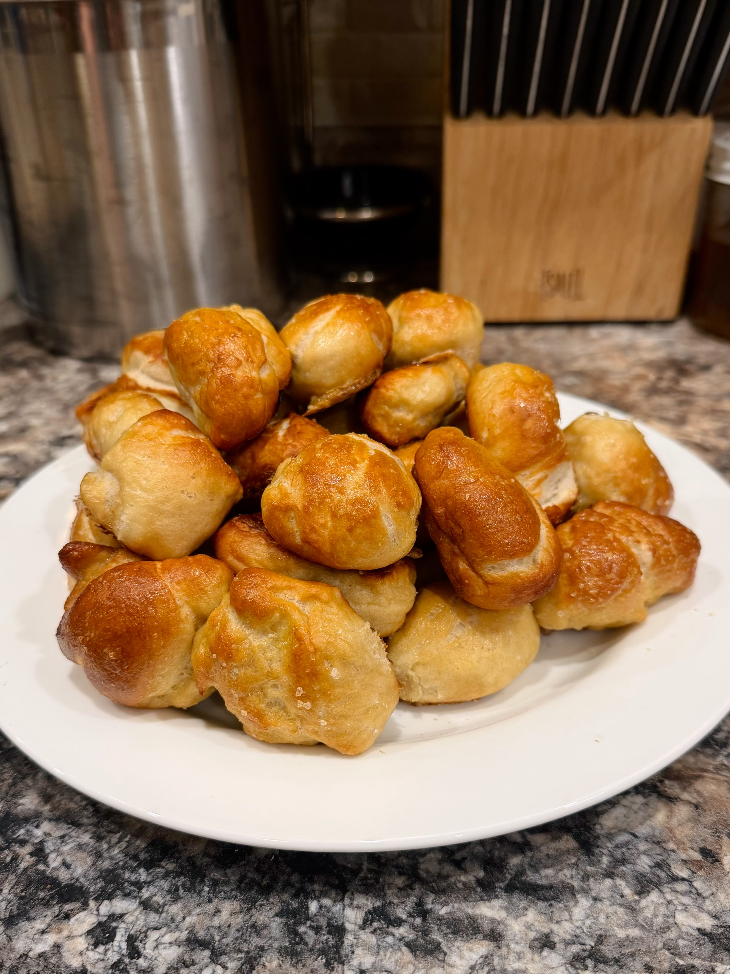 A plate piled high with homemade golden sourdough pretzel bites